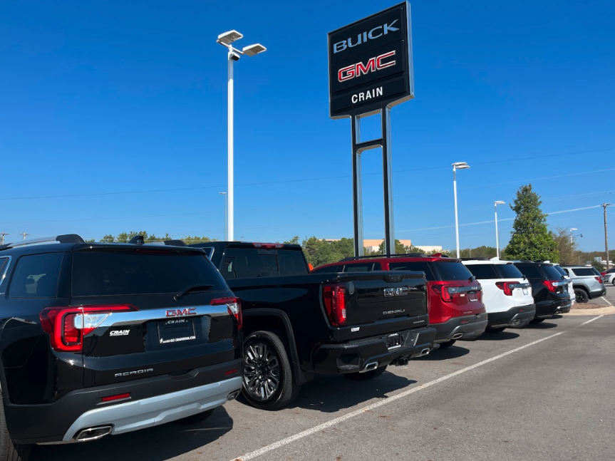 Lineup of GMC SUVs and trucks parked under the Crain Buick GMC sign in Conway, Arkansas